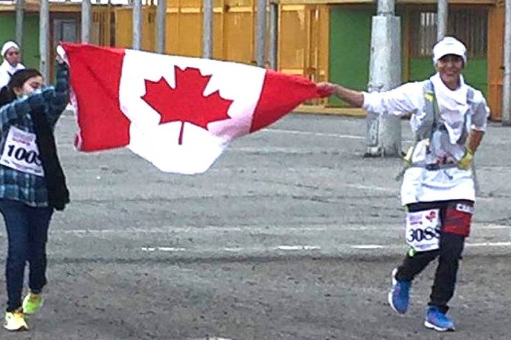 Haleh Magnus and her daughter Lyla running to the finish line of the 2017 Tehran Marathon with the Canadian flag